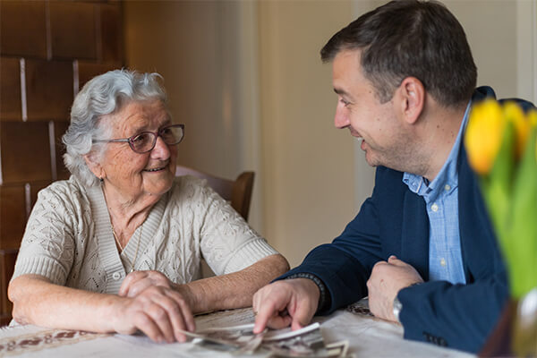 Man talking and smiling with senior woman.