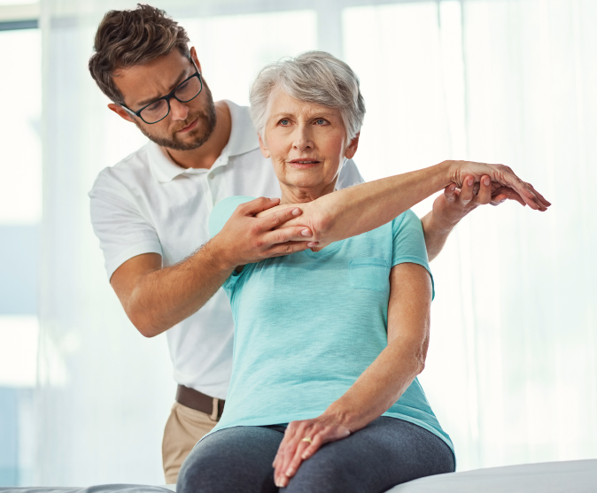 senior woman stretching with the help of a rehab therapist
