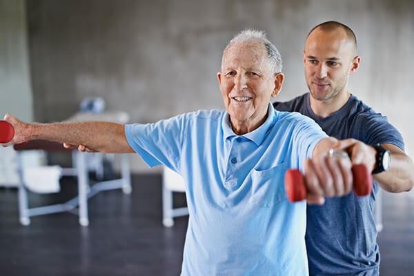 Trainer with senior lifting weights.